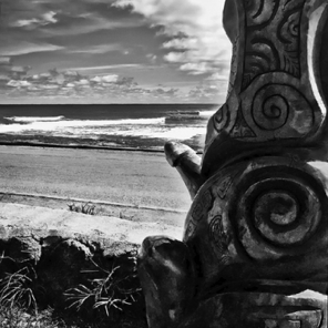 Large carving in front of a community building facing the sea • iPhone image from the back…